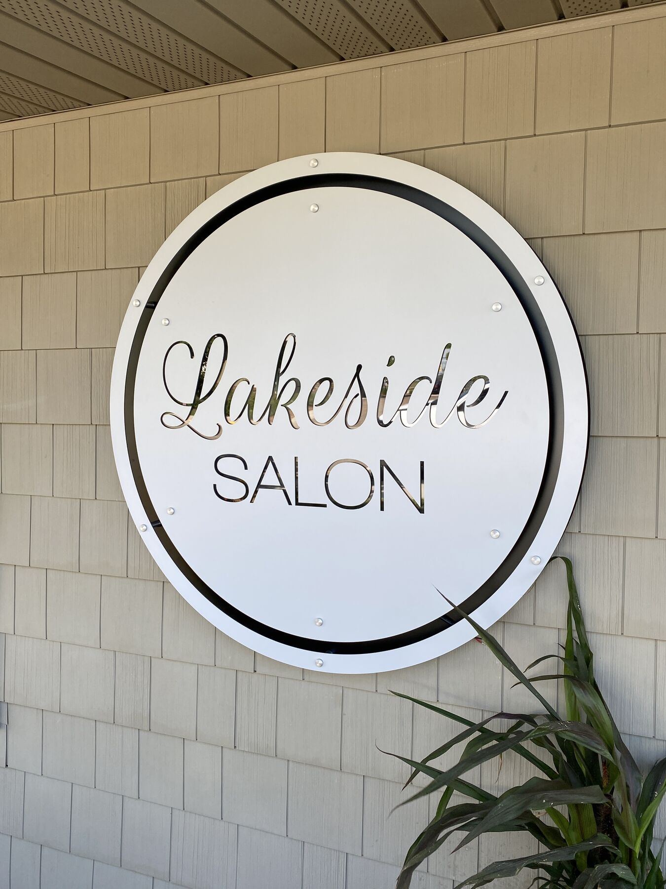 Round Lakeside Salon sign installed on an exterior wall