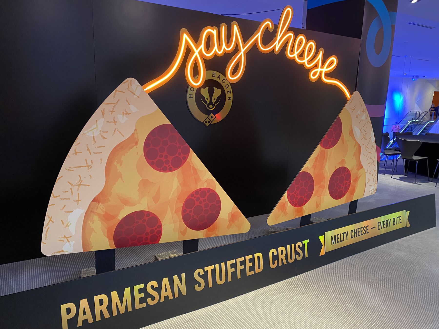 Say Cheese illuminated lettering above dimensional pizza-slice display